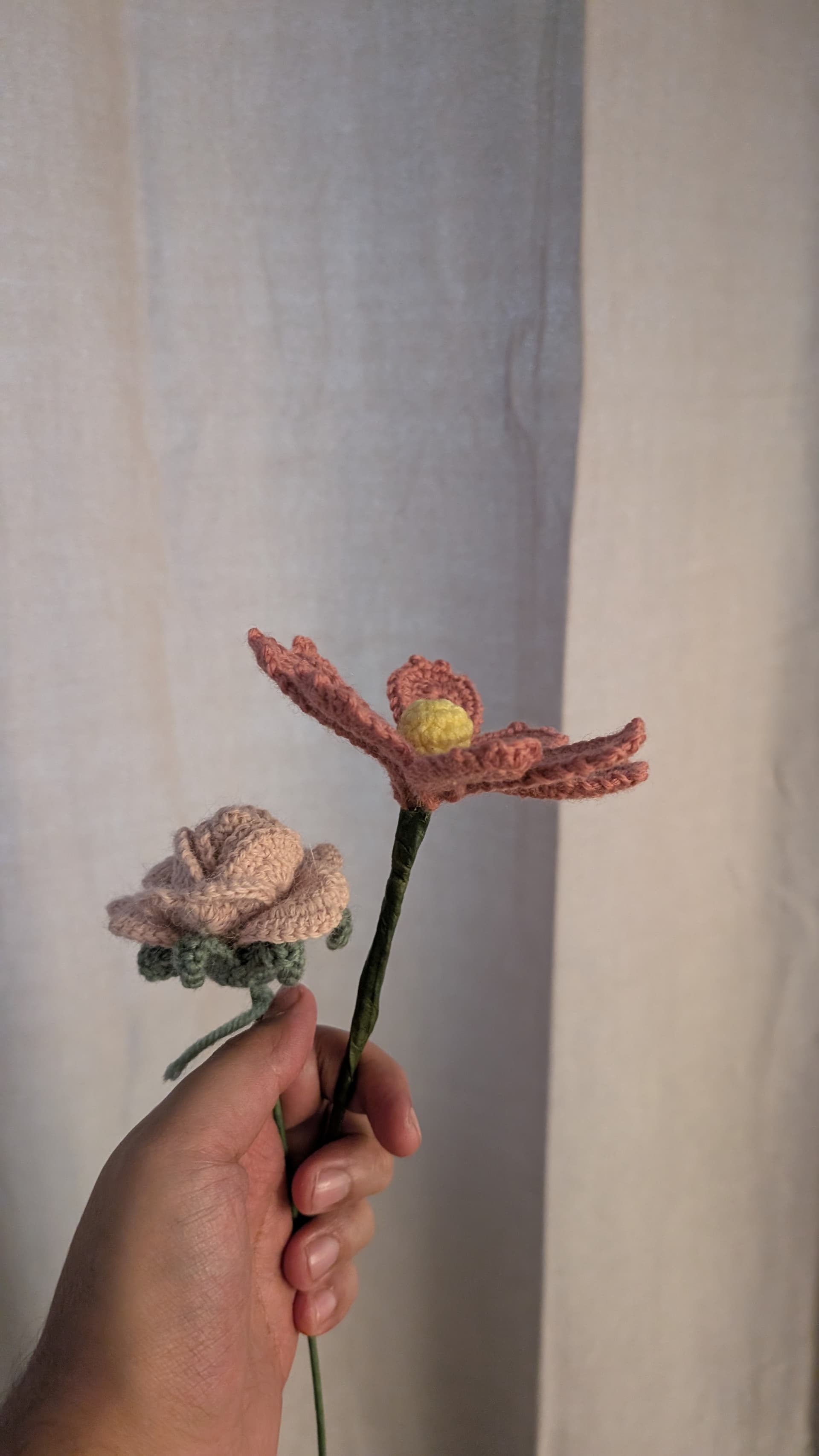 A pink crocheted flower with a yellow center